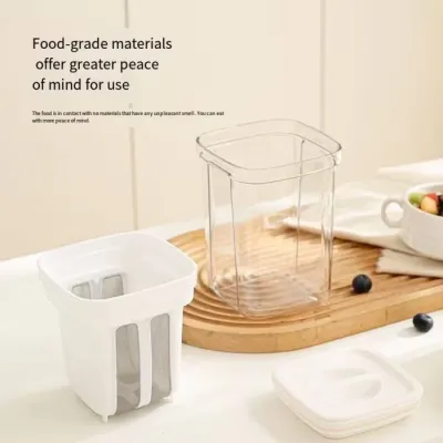 The disassembled components of a Greek Yogurt Strainer including the clear outer container, inner mesh, and white lid.