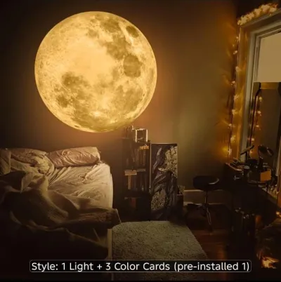 Moon Lamp projecting a warm golden glowing moon on a bedroom wall above a cozy bed setup.